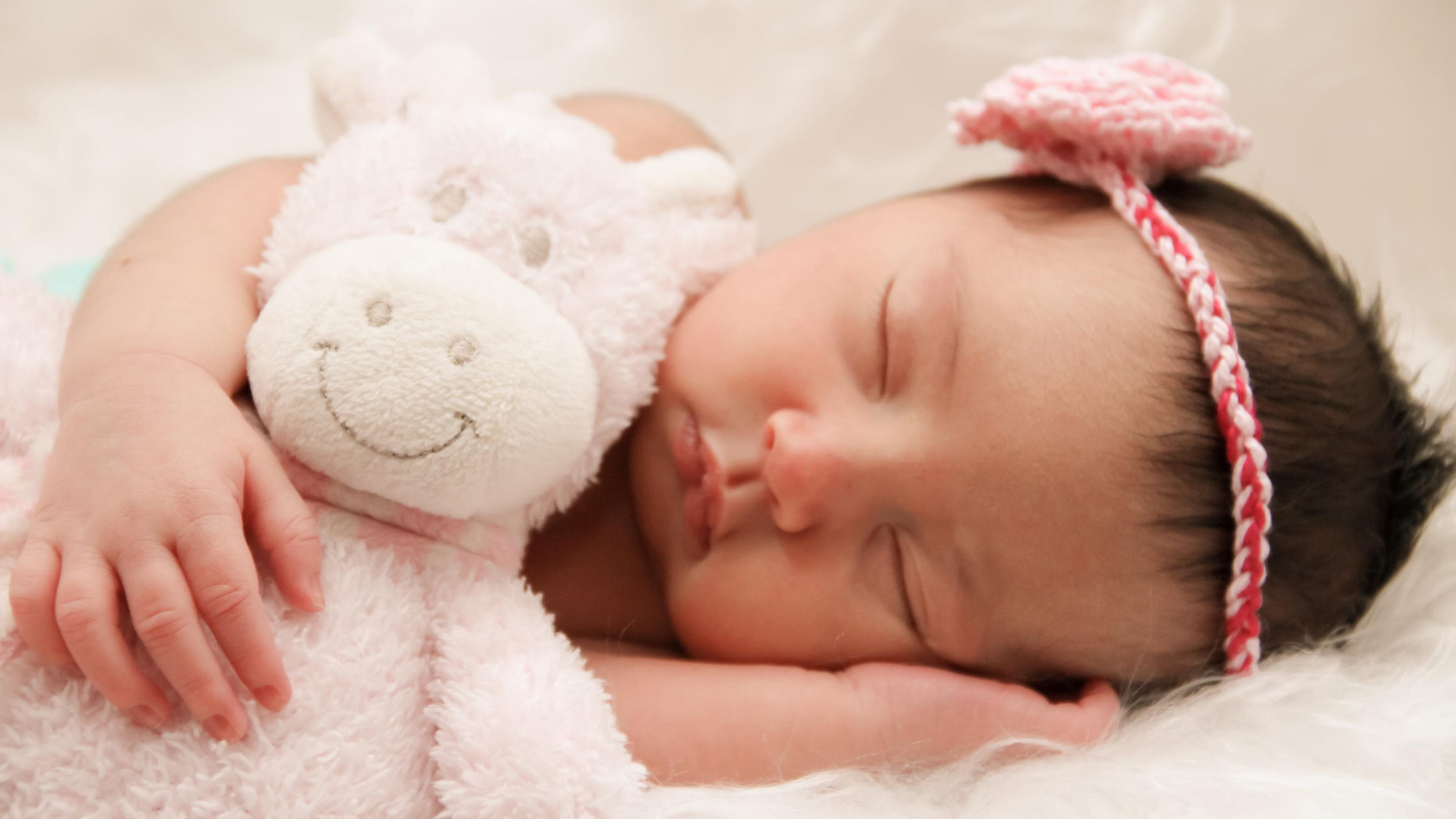Baby sleeping with cuddly toy