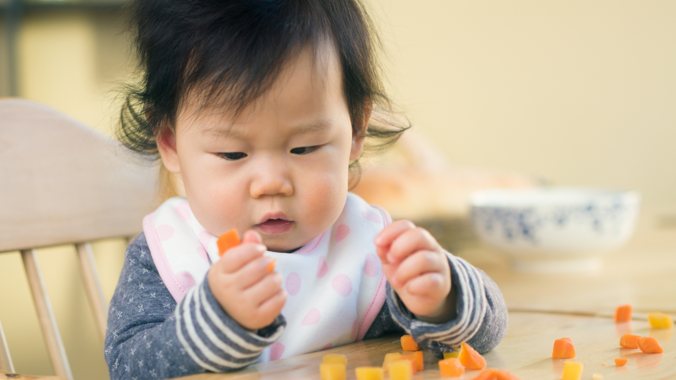 baby eating vegetables cut up into squares